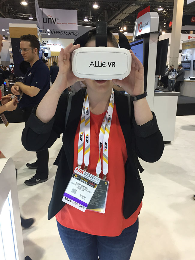 Associate Content Editor, Sydny Shepard, tries on the IC Real Tech ALLie Virtual Reality headset that streams video from the ALLie 360x360 degree camera at the ISC West show in Las Vegas.