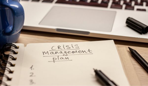 crisis management plan written words in notebook