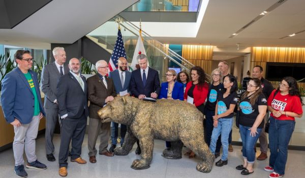 Governor Gavin Newsom signs legislation to strengthen worker protections with legislators, labor leaders, and workers