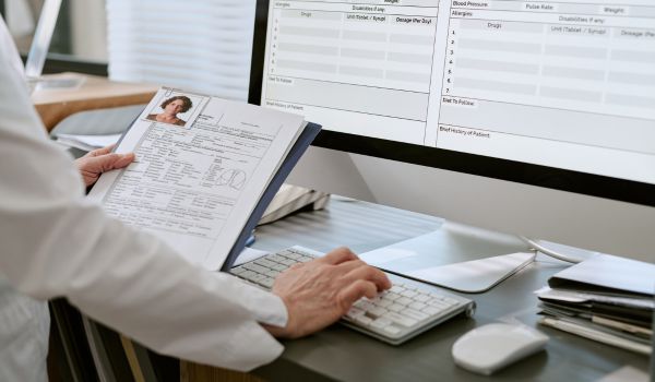 Doctor entering patient information on computer