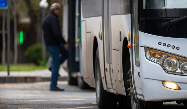 Passenger boards a bus at a roadside stop.
