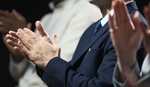 Business professionals clapping during corporate event, showing recognition, support, teamwork, and success