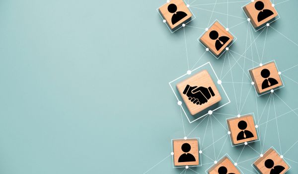 Top view design on blue background of Hand shaking which print screen on wooden cube blocks