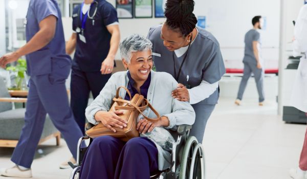 Doctor escorting patient in wheelchair