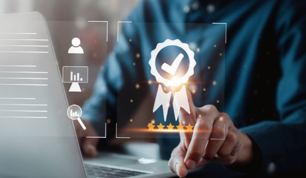  A person uses a laptop, touching a glowing digital certificate icon with a checkmark and five stars.  