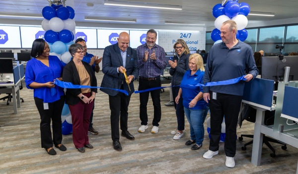 ADT Monitoring staff cutting blue ribbon