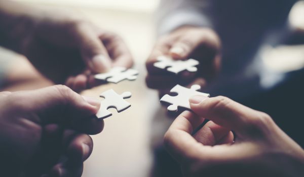 Hands holding jigsaw puzzles as business partnership concept