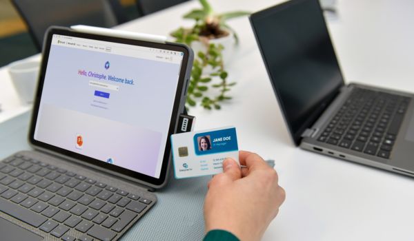Person working on laptop while holding keycard