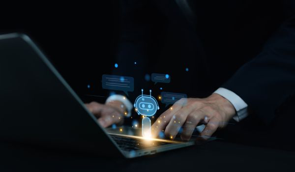 Person typing on laptop with AI logo overlay