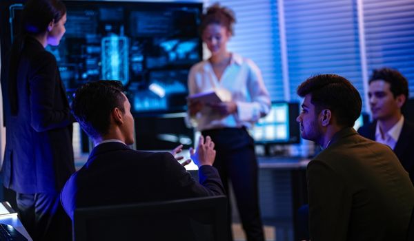 Confident businesswoman presenting global data analysis to team on large digital screen