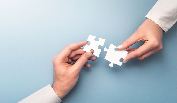 Two people holding puzzle pieces