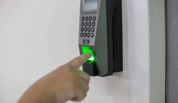 Person scanning fingerprint for building access