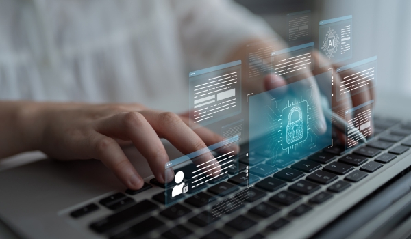Hands typing on a laptop keyboard surrounded by floating digital graphics of lock icons, user profiles, AI, and data windows.