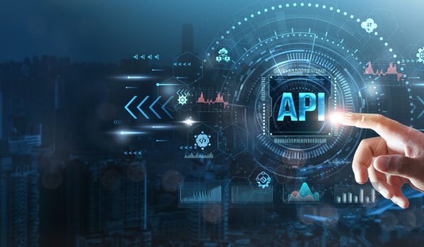 Hand touching a digital interface labeled “API,” surrounded by charts and network icons.