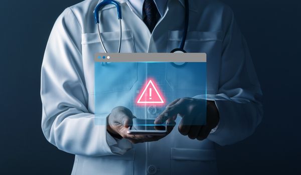Doctor holding smartphone with data breach icon overlayed