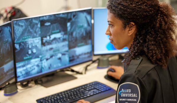 Professional with Allied Universal uniform staring at security footage