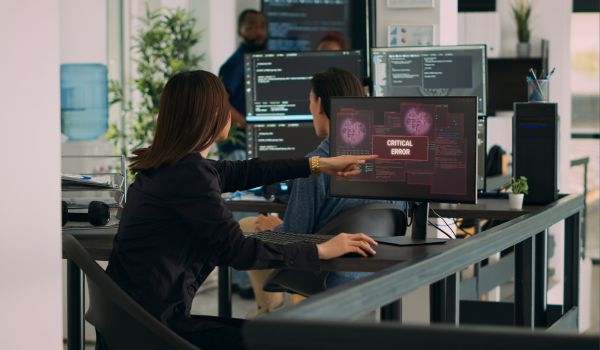 Person pointing at system error on computer screen