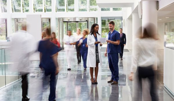 Staff In Busy Lobby Area Of Modern Hospital