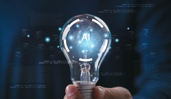 A hand holding a clear lightbulb with a glowing digital brain circuit and the letters "AI" inside, set against a dark blue background with abstract tech diagrams.