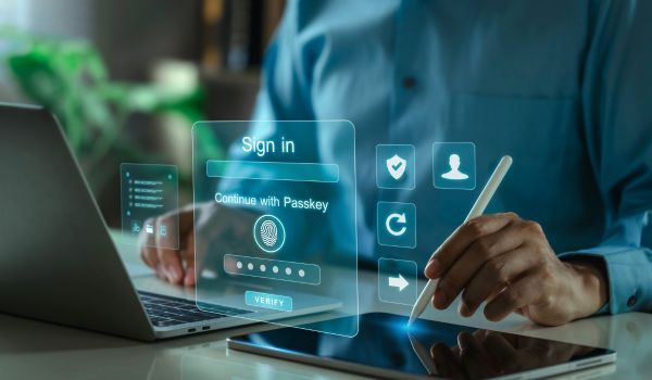 Person using passkey authentication on a laptop and tablet.
