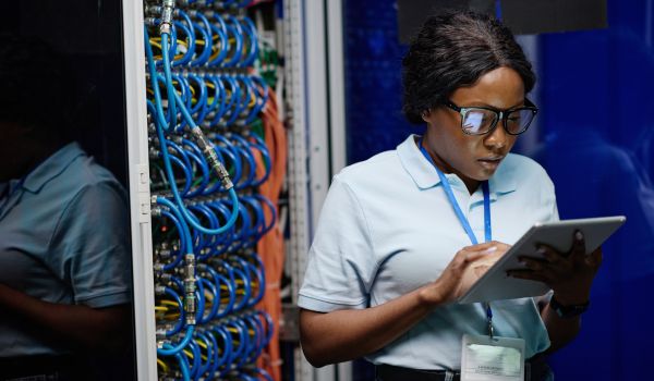 Technician working on tablet near circuit board