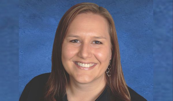 Headshot of Kat Tallman on a blue background