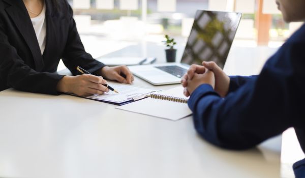 Two people sitting across from one another at desk