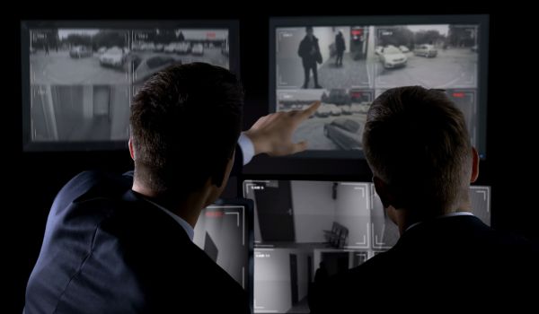 Private agents monitoring CCTV footage, searching for criminal