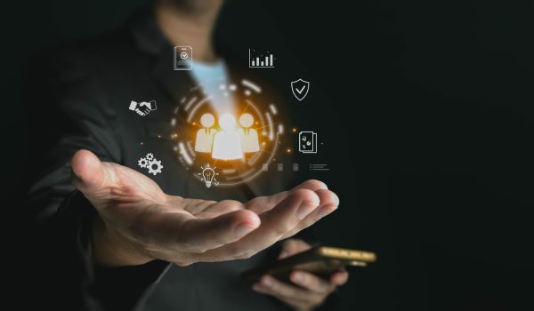 Businessman holding a smartphone and projecting a glowing hologram graphic