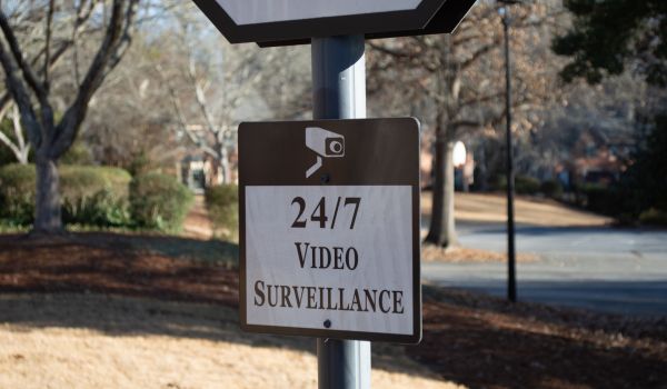 Close-up of a brown 24/7 video surveillance warning sign